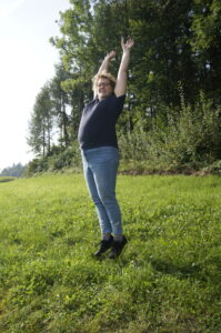 Claudia Kalbermatter springt in die Höhe vor Wald